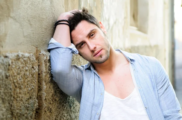 Portrait of young handsome man in urban background — Stock Photo, Image