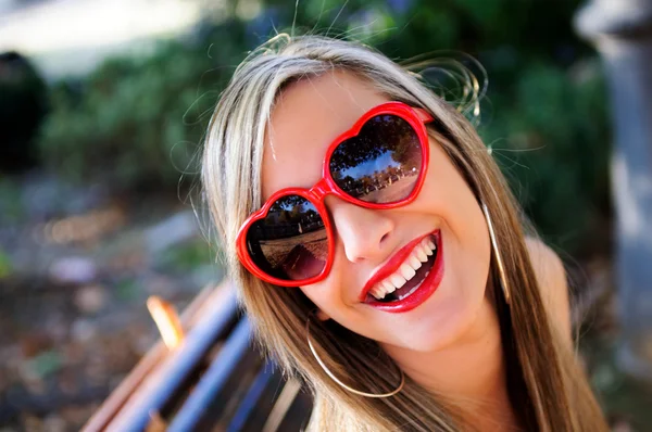Menina engraçada com óculos de coração vermelho — Fotografia de Stock