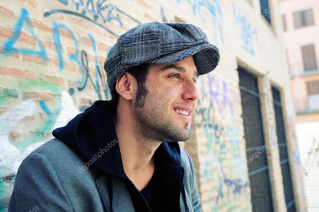 Portrait of handsome man in urban background wearing a retro cap