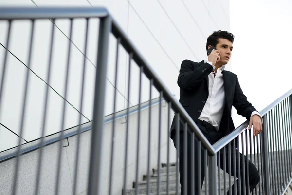 Young businessman, in an office building talking on the phone — Stock Photo, Image