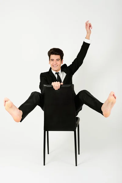 Щасливий бізнесмен сидить у кріслі з піднятою рукою — стокове фото
