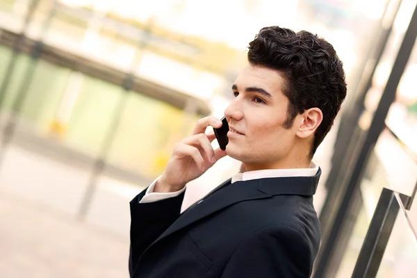 Junger Geschäftsmann in einem Bürogebäude telefoniert — Stockfoto