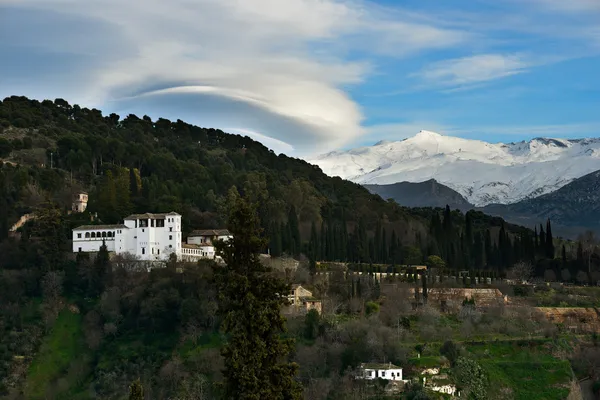 Alhambra and snowing Sierra Nevada mountains under a lenticular — Stock Photo, Image