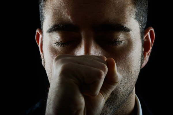 Человек с кулаком и закрытыми глазами
