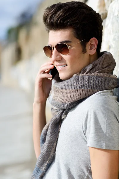 Yakışıklı bir adam telefonda konuşurken kentsel arka planda — Stok fotoğraf