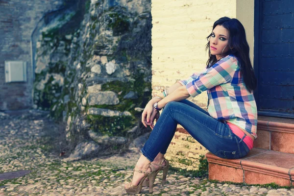 Joven hermosa mujer en un fondo urbano — Foto de Stock