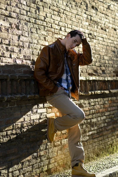 Hombre guapo con peinado moderno sonriendo en el fondo urbano —  Fotos de Stock