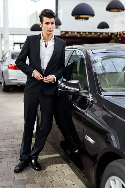 Joven hombre guapo, modelo de moda, con coches de lujo — Foto de Stock