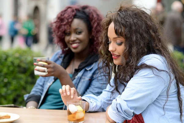 Portret van twee vrouwen nemen van een drankje in een bar. stedelijke achtergrond — Stockfoto