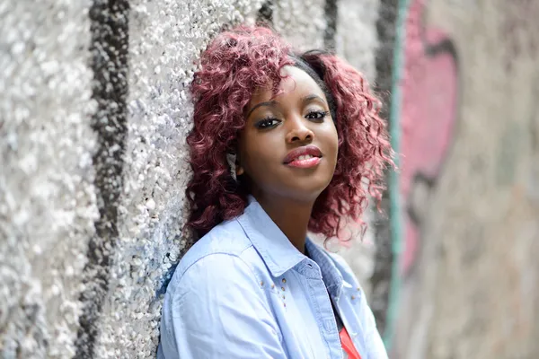 Hermosa mujer negra en fondo urbano con el pelo rojo — Foto de Stock