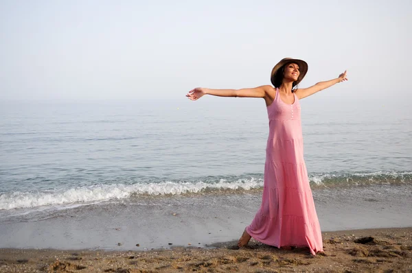 Mooie vrouw met lang roze jurk op een tropisch strand — Stockfoto