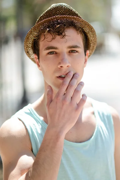 Yakışıklı bir adam güneş şapkası kentsel arka planda — Stok fotoğraf