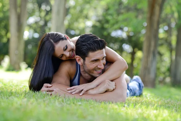 Feliz casal sorrindo deitado na grama verde — Fotografia de Stock