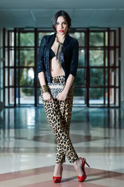 Ung vacker kvinna som bär leopard byxor — Stockfoto