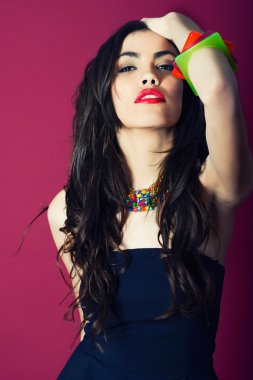 kırmızı zemin üzerine genç kadının güzelliği. bilezik takıyor