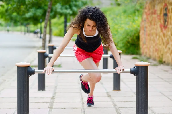 Joven mujer sonriente alegre en ropa deportiva en el fondo urbano —  Fotos de Stock