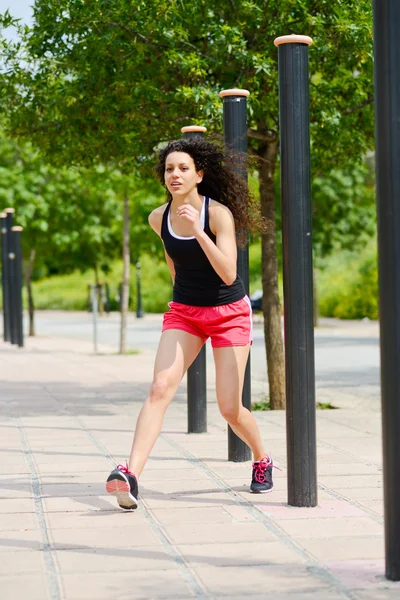 Молодая веселая улыбающаяся женщина в спортивной одежде на городском фоне — стоковое фото