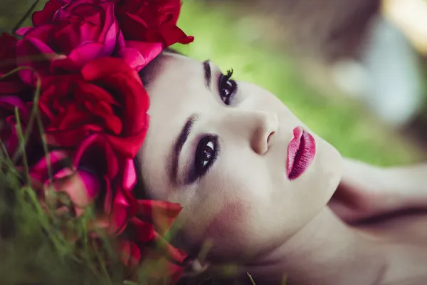 Молодая красивая японская женщина с розовыми и красными цветами — стоковое фото