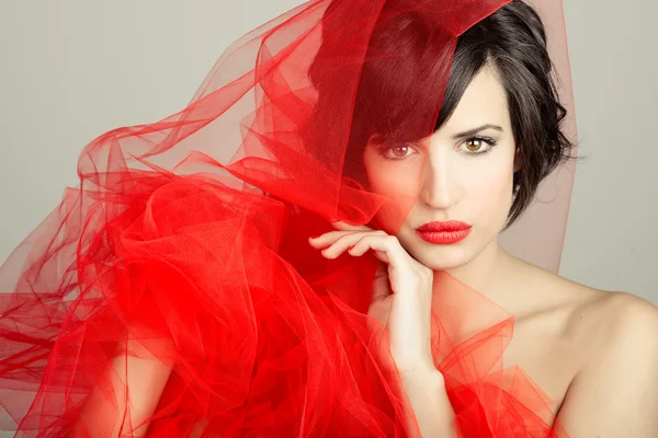 Beautiful girl with a red tulle. Studio photograph — Stock Photo, Image