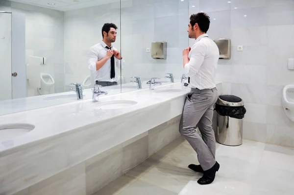 Homem se vestindo em um banheiro público com espelho — Fotografia de Stock