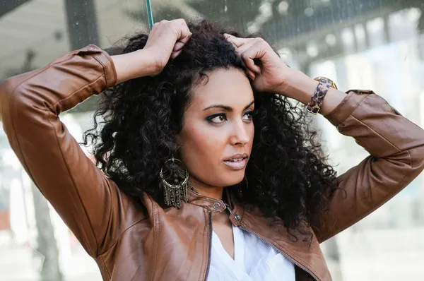 Jeune femme noire, coiffure afro, en fond urbain — Photo