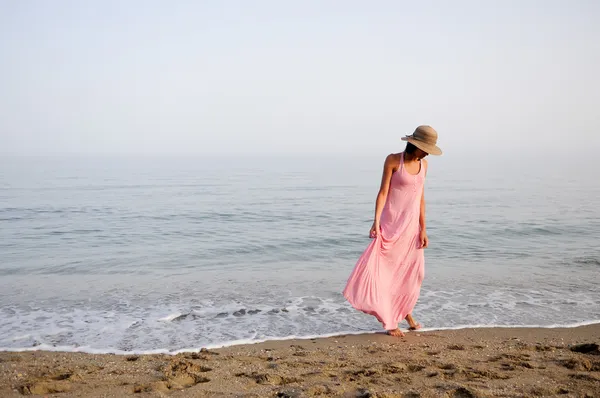 Mulher bonita com vestido rosa longo em uma praia tropical — Fotografia de Stock