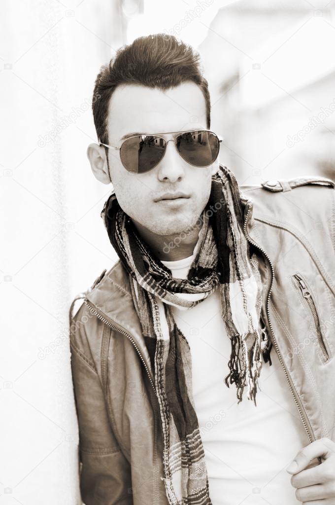 Attractive man with tinted sunglasses in urban background