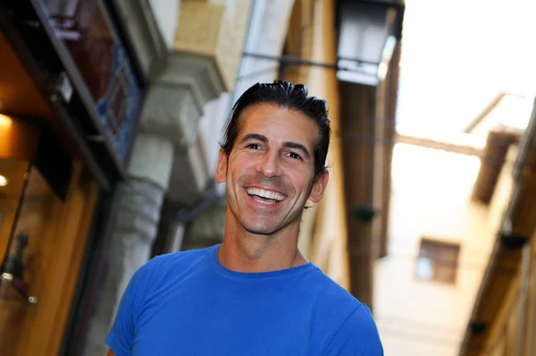 Aantrekkelijke lachende man portret in stedelijke achtergrond — Stockfoto