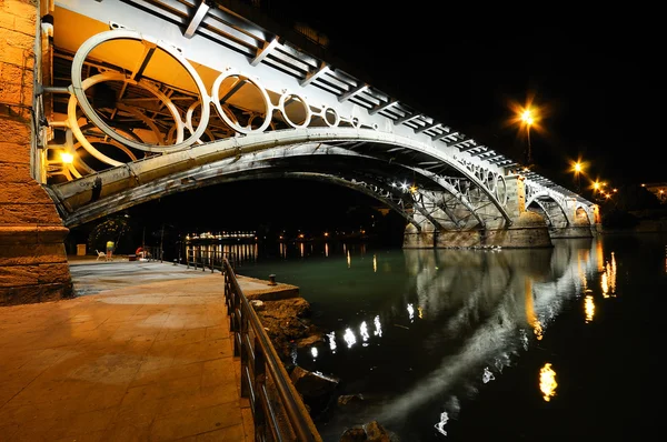 Puente de Triana sobre el río Guadalquivir al atardecer con refle fluvial — Foto de Stock