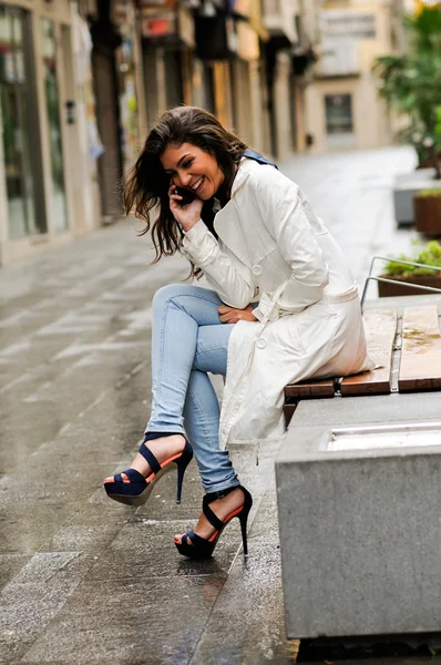 Hermosa joven en el fondo urbano hablando por teléfono — Foto de Stock