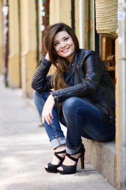 Lea giyen kentsel arka planda gülümseyen güzel bir Japon kadın