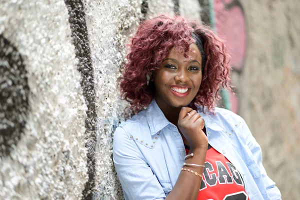 Beautiful black woman in urban background with red hair — Stock Photo, Image