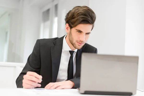 Geschäftsmann sitzt an seinem Laptop und arbeitet im Büro — Stockfoto