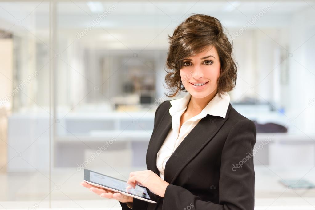 Young pretty business woman with tablet computer in the office 