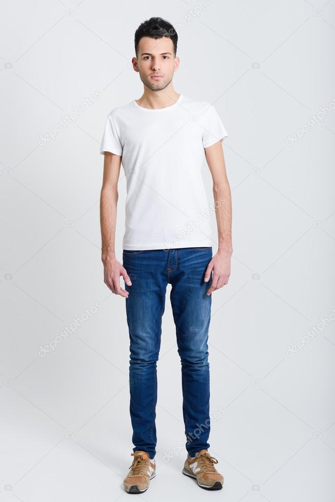 Serious young man standing against white background 