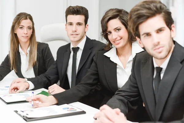 Equipe de negócios olhando para a câmera no ambiente de trabalho — Fotografia de Stock