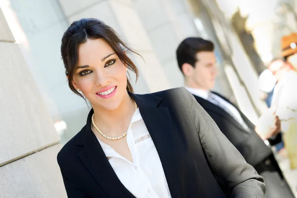 Attractive businesswoman standing outside of company building. C — Stock Photo, Image