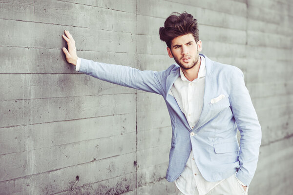 Attractive young handsome man, model of fashion in urban backgro