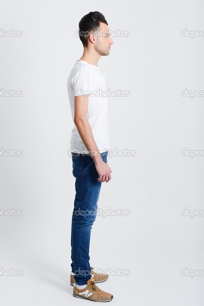 Serious young man standing against white background 