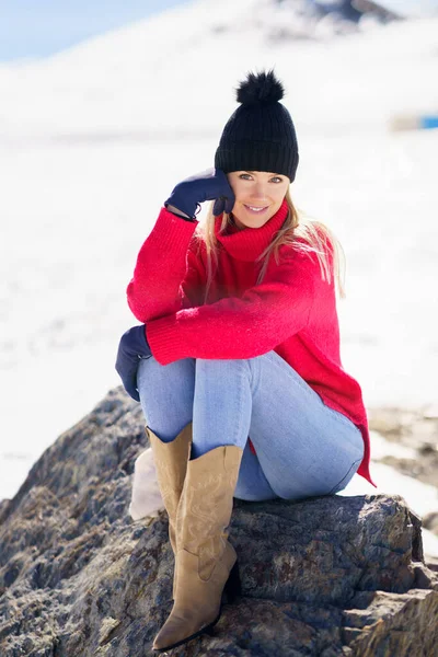 Mujer joven sentada en una roca en las montañas nevadas en invierno, en Sierra Nevada, Granada, España. —  Fotos de Stock