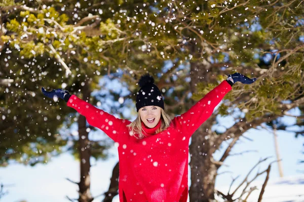 Egy nő hógolyókat dob a feje fölé egy havas erdőben a hegyekben.. — Stock Fotó