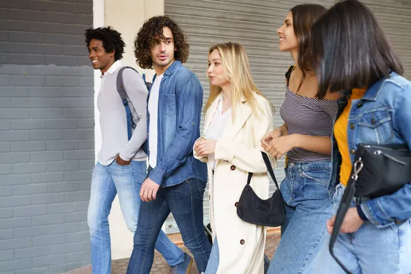Grupo multiétnico de amigos caminando juntos en la calle. — Foto de Stock