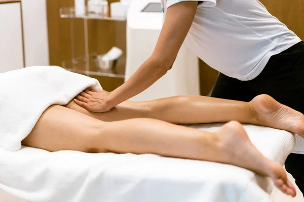 Femme d'âge moyen ayant un massage des jambes dans un salon de beauté. — Photo