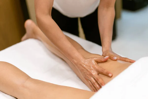 Salon piękności profesjonalne wylewanie oleju ze świecy do masażu na plecach pacjenta. — Zdjęcie stockowe