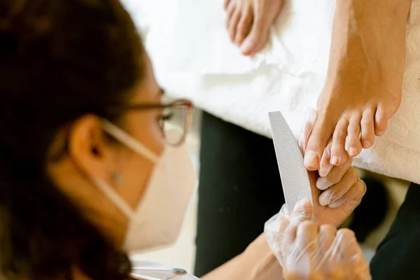 Косметолог дає педикюр, малюючи нігті своїх клієнтів в центрі краси . — стокове фото