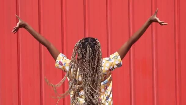 Afrikanisches Mädchen mit farbigen Zöpfen gekämmt, die sie fallen lassen. Typisch afrikanische Frisur. — Stockvideo