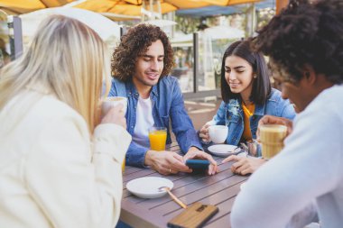 Bir sokak barının terasında içki içen çok ırklı bir grup öğrenci..