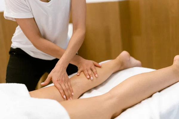 Femme d'âge moyen ayant un massage des jambes dans un salon de beauté. — Photo