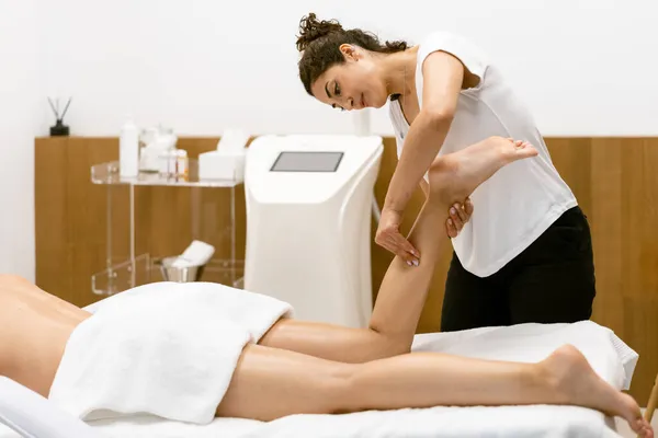 Mulher de meia-idade tendo uma massagem nas pernas em um salão de beleza. — Fotografia de Stock