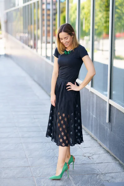 बाहेर स्कर्ट आणि हिरव्या उच्च हील परिधान आकर्षक महिला . — स्टॉक फोटो, इमेज